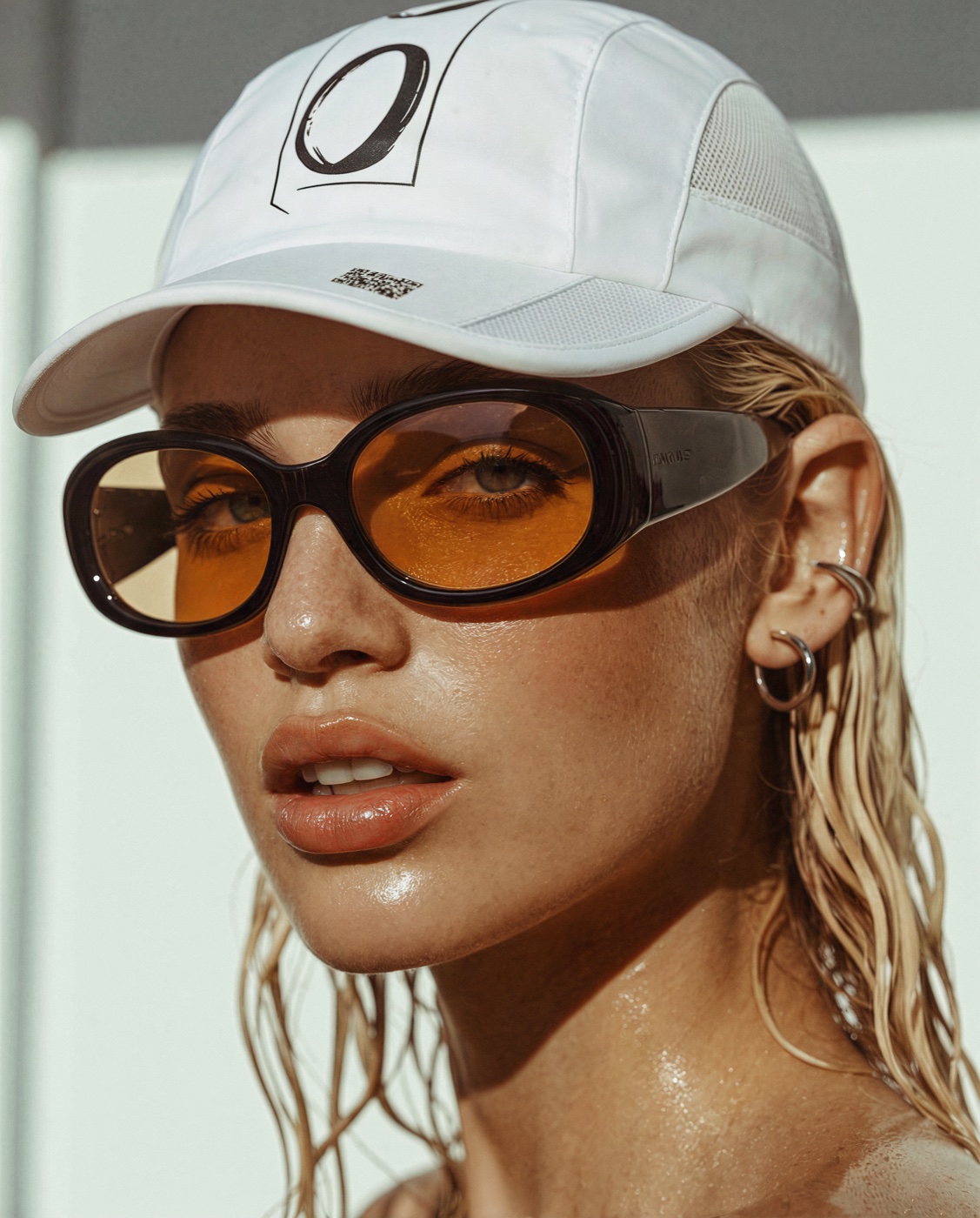 002 campaign — beauty portrait, branded cap